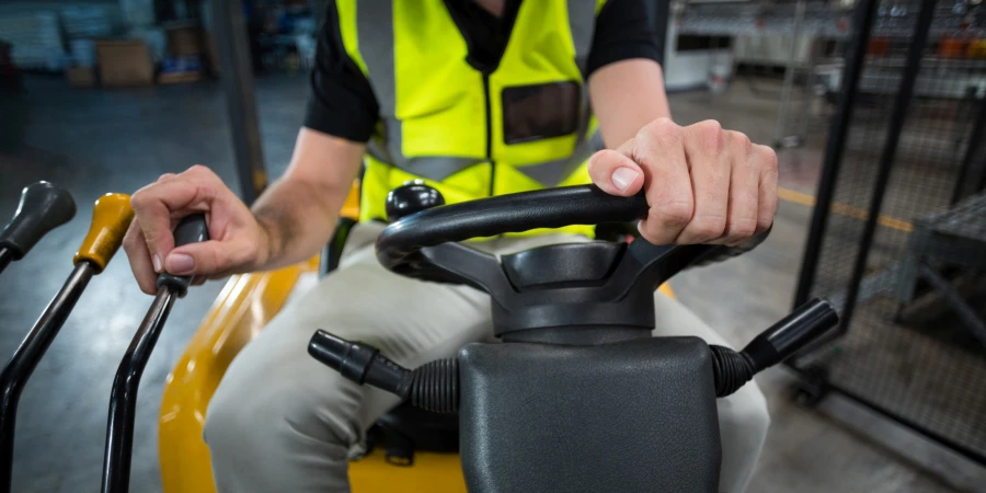 Factory worker driving forklift in factory